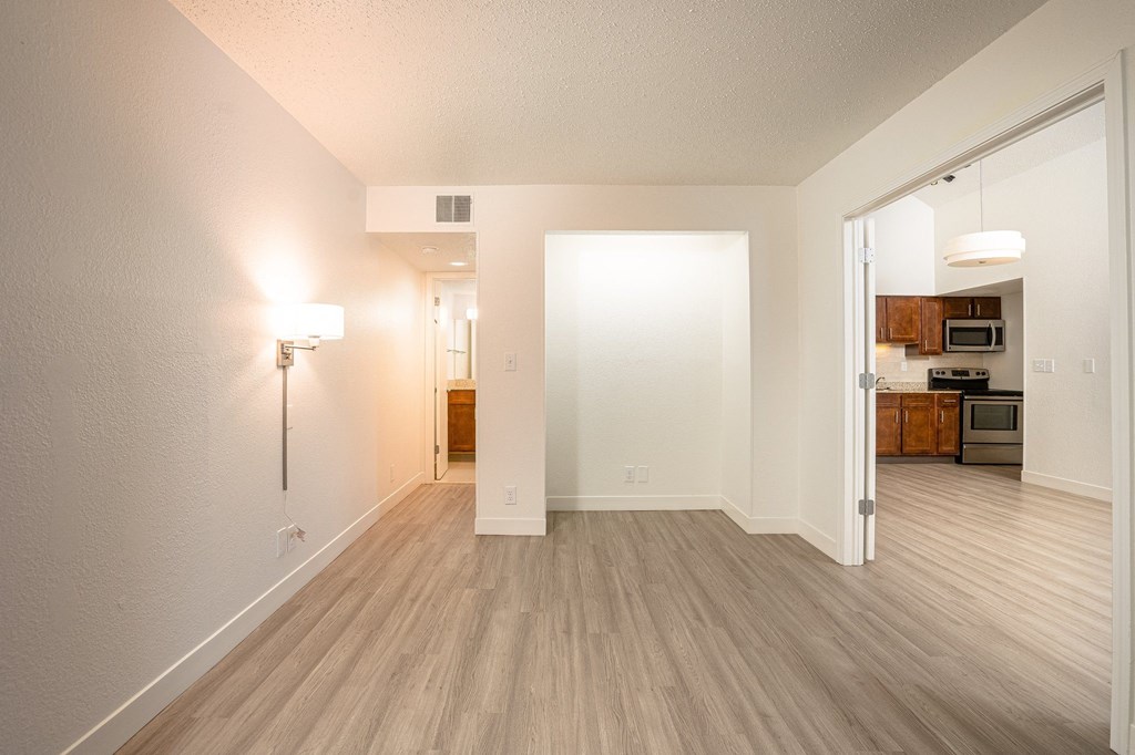 a bedroom with hardwood floors and white walls